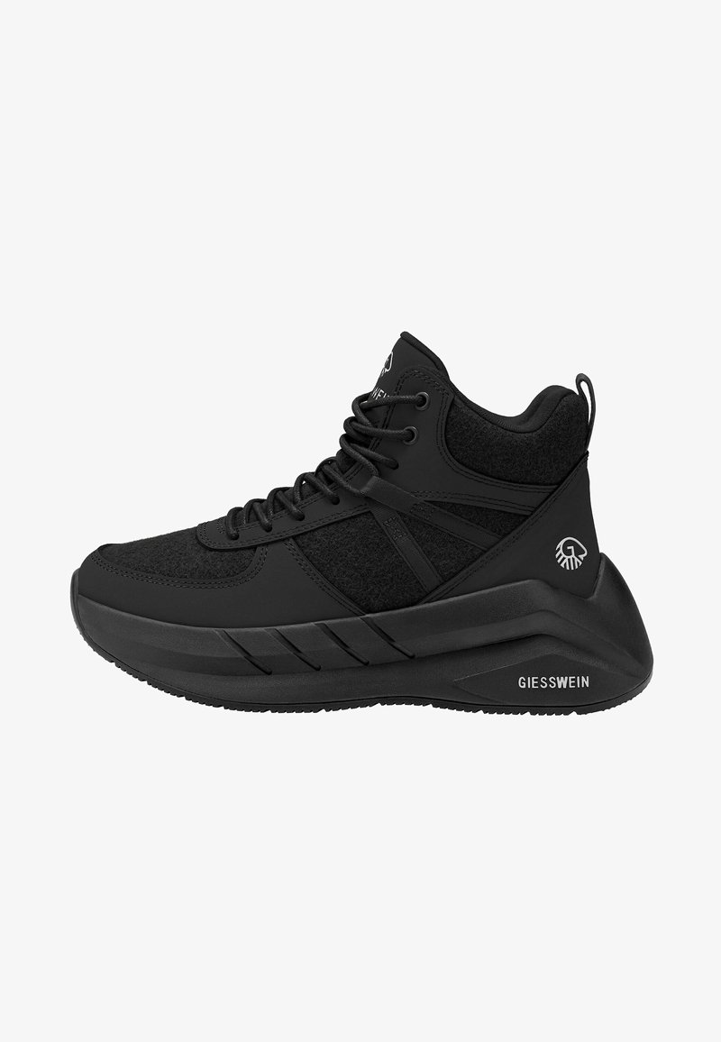 Zwarte hoge sneaker met dikke zool, textuurstofpanelen, veters aan de voorkant en Giesswein-logo op hiel en zool.