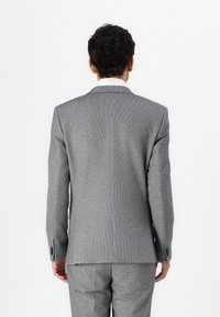 Grå mønstret dressjakke med slim fit, standard slag og knappefeste; stoffet har en subtil tekstur, skreddersydd design.