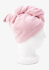 Pink microfiber hair towel with a twisted top, designed to hold hair. Textured surface, lightweight, and compact for easy use.