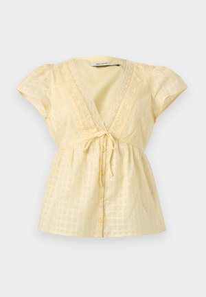 Ελαφρύ κίτρινο κοντομάνικο μπλουζάκι με V-λαιμόκοψη, δαντέλα στην μπορντούρα, κουμπιά στο μπροστινό μέρος, κορδόνι στη μέση και διακριτικό καρό σχέδιο.