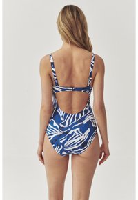 Badeanzug mit blauem Zebra-Muster, einem Ausschnitt im Rücken, verstellbaren Trägern und einer glatten, dehnbaren Stofftextur.