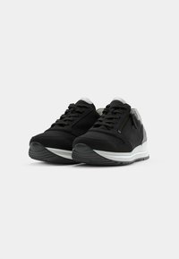 Black athletic shoes with a sleek design, featuring a textured fabric upper, silver accents, and a contrasting white midsole.