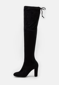 Botas negras de ante por encima de la rodilla con punta redonda, tacón alto y cuadrado, y detalle de lazo ajustable en la parte superior para un ajuste seguro.