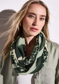 Multikleurige infinity-sjaal in groene tinten, met een mix van abstracte patronen en luipaardprints, gemaakt van lichtgewicht, gladde stof.