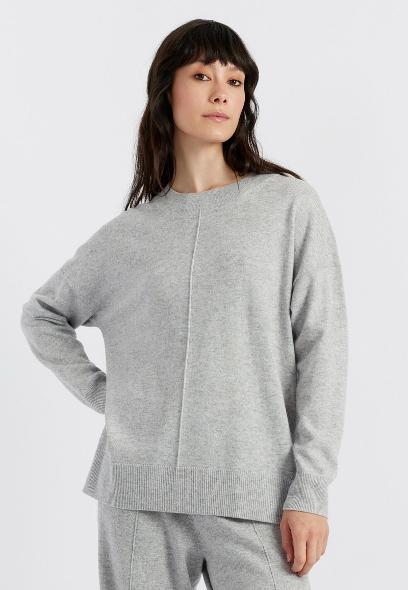 Grauer Strickpullover mit lockerer Passform, Rundhalsausschnitt und gerippten Bündchen und Saum. Merkmale ein strukturiertes Muster und seitliche Schlitze für Bewegungsfreiheit.