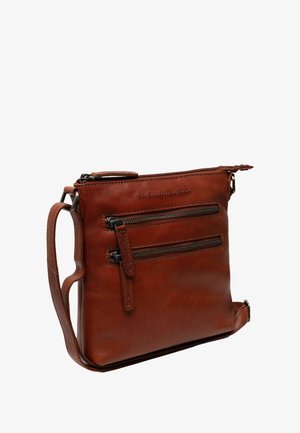 Braune Leder-Crossbody-Tasche mit glatter Textur, mehreren Reißverschlusstaschen, verstellbarem Schulterriemen und geprägtem Logo auf der Vorderseite.