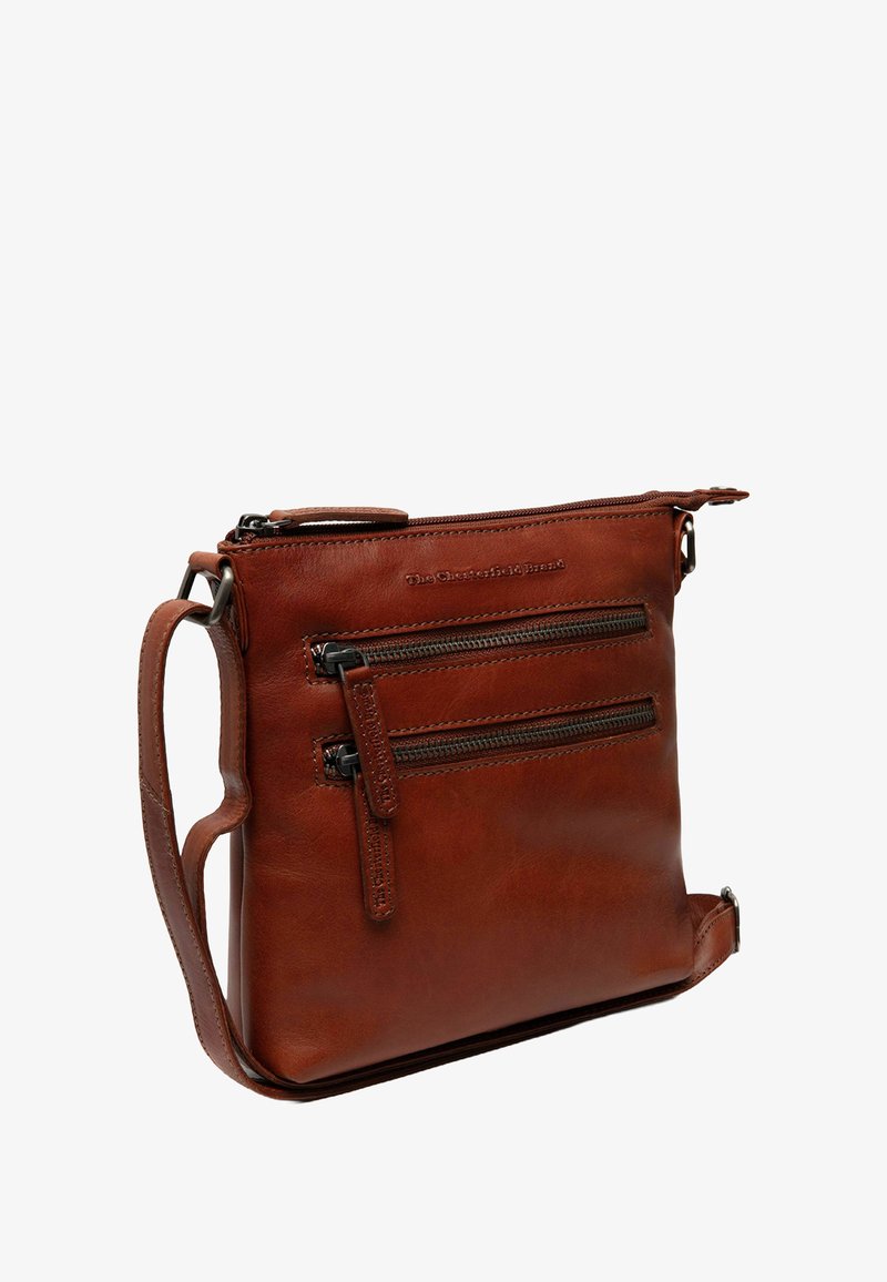 Braune Leder-Crossbody-Tasche mit glatter Textur, mehreren Reißverschlusstaschen, verstellbarem Schulterriemen und geprägtem Logo auf der Vorderseite.