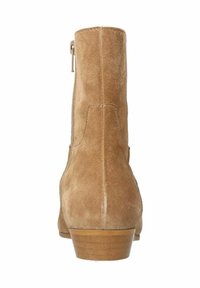 Bottines en suede beige avec une fermeture éclair à l'arrière, un bout arrondi et un petit talon empilé. Texture lisse avec des détails de couture visibles.