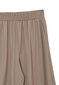 Pantaloni beige con vita elastica, tasche laterali, texture liscia e vestibilità comoda. Presentano una leggera lucentezza e un tessuto leggero.