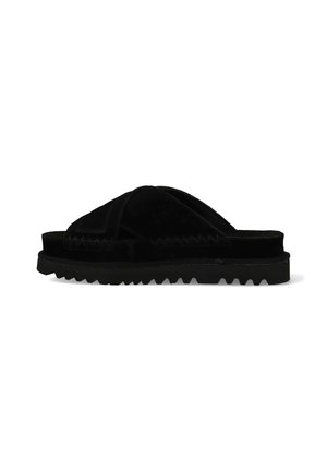 Zwarte slip-on sandaal met gekruiste fluwelen bandjes en dikke gekartelde zool, zijaanzicht op witte achtergrond.
