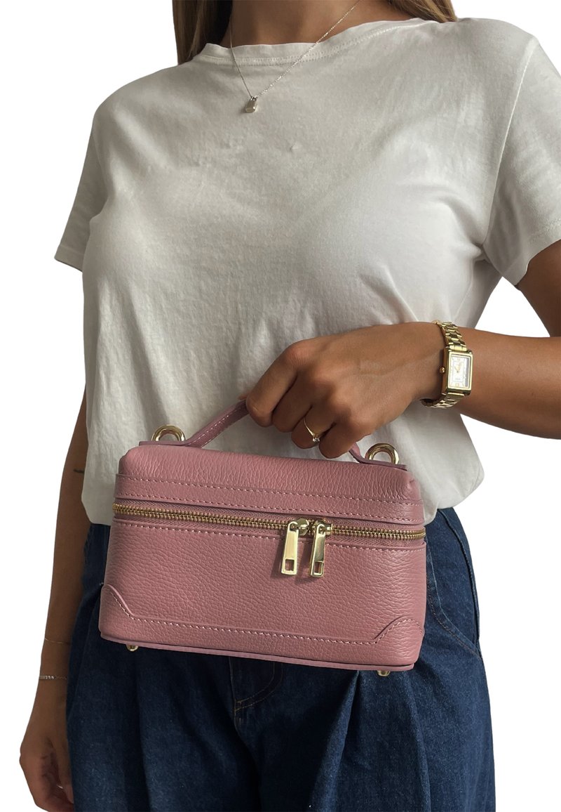 Różowa skórzana torebka o zwartej, prostokątnej formie, z górnym uchwytem, podwójnymi zamkami błyskawicznymi i złotymi akcentami metalowymi. Powierzchnia o fakturze.