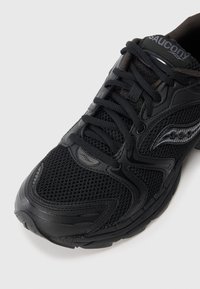 Schwarzer Laufschuh mit einem Obermaterial aus Mesh, synthetischen Überzügen und einfarbigen Schnürsenkeln. Gummisohle mit ausgeprägten Profilmustern und Markenlogo.