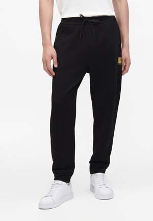 Armani Exchange Pantalon de survêtement - black/gold-coloured