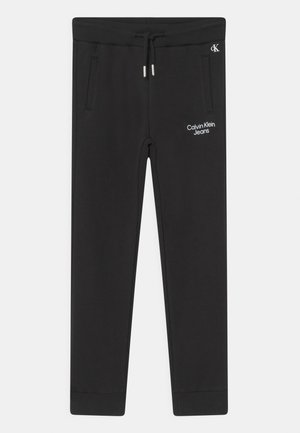 Sorte Calvin Klein joggebukser med ribbet talje og manchetter, snøre, sidelommer og hvid "Calvin Klein Jeans"-logo på venstre lår.