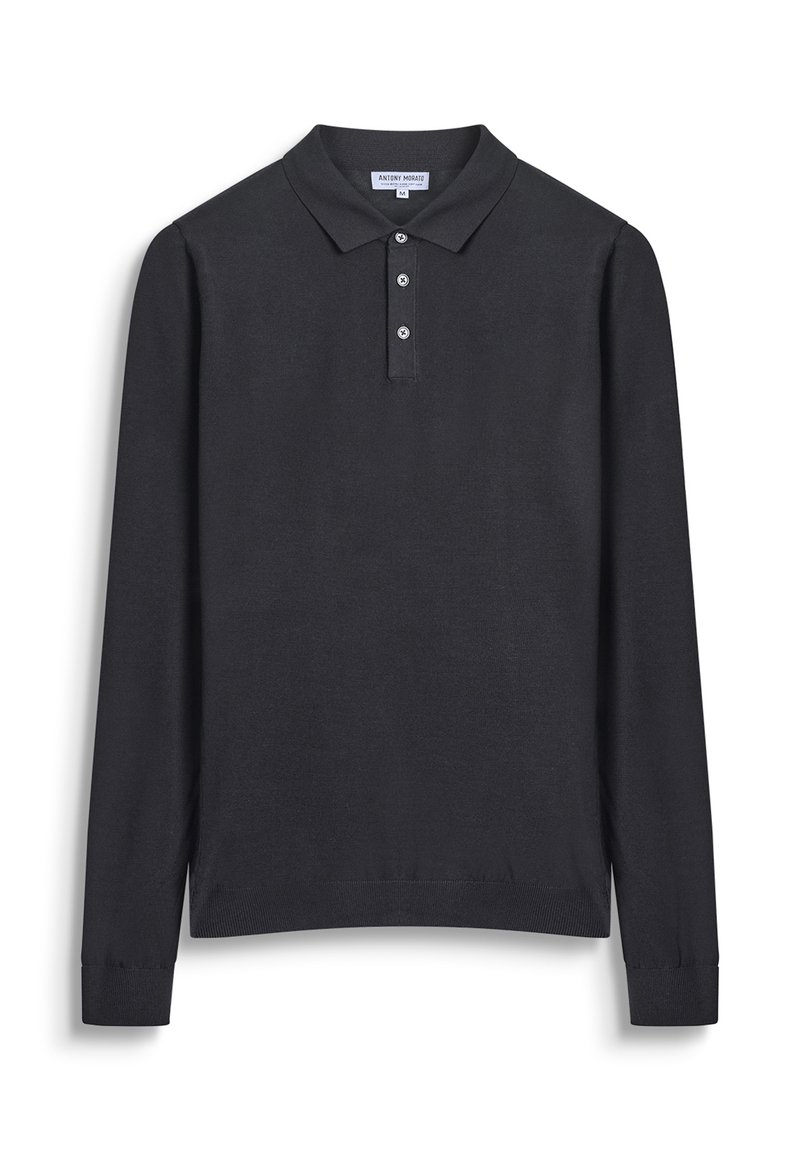 Crna polo majica dugih rukava s ovratnikom, tri gumbića sprijeda i rebrastim manžetama. Napravljena od glatkog, laganog materijala.