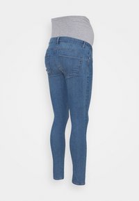 Schwangerschaftsjeans aus einem Gemisch aus hellblauem Denim und einem weichen grauen elastischen Bund, schlanker Schnitt mit Gesäßtaschen.
