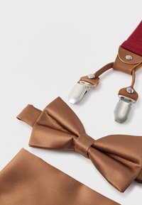 Gravata borboleta de cetim castanha com fita de pescoço correspondente, acompanhada de suspensórios bordô com detalhes em couro castanho e presilhas de metal prateado.