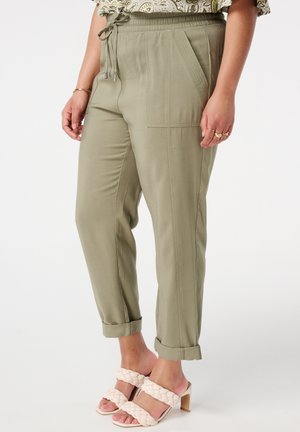 Lichtgroene, lightweight broek met een elastische tailleband, koord en zijzakken. Aangerimpeld bij de enkels, hebben ze een soepele textuur.