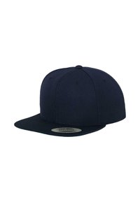 Mørkeblå snapback-hat med flad skygge, lavet af tekstureret stof, med ventilationshuller og en cirkulær logo-detalje.