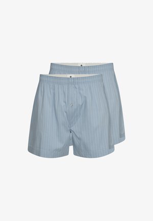 Ljust blå bomullskalsonger med vertikala vita ränder; elastisk midjeband och en knappöppning. Två par visas.