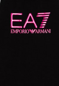 Fekete pamut ujjatlan felső, az élénk rózsaszín "EA7 EMPORIO ARMANI" logóval. A logón különböző vastagságú vonalak és egy középső sas embléma található.