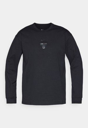 Zwarte langemouwen Nike-shirt met een ronde hals en een glanzende zwarte stierenafbeelding gecentreerd op de borst. Zacht, katoenblend materiaal.