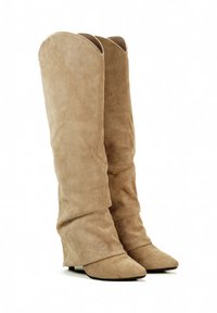 Bottes en suède beige hauteur genou avec un design froncé, orteils pointus et un petit talon, mettant en valeur une texture douce et une finition lisse.