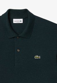 Dunkelgrünes Lacoste-Polo-Shirt mit klassischer Passform, Zwei-Knopf-Leiste und gesticktem Krokodil-Logo auf der linken Brust. Strukturiert.