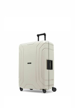 Witte harde koffer met vier wielen, telescopisch handvat en zijkombinatieslot, rechtopstaand op witte achtergrond.