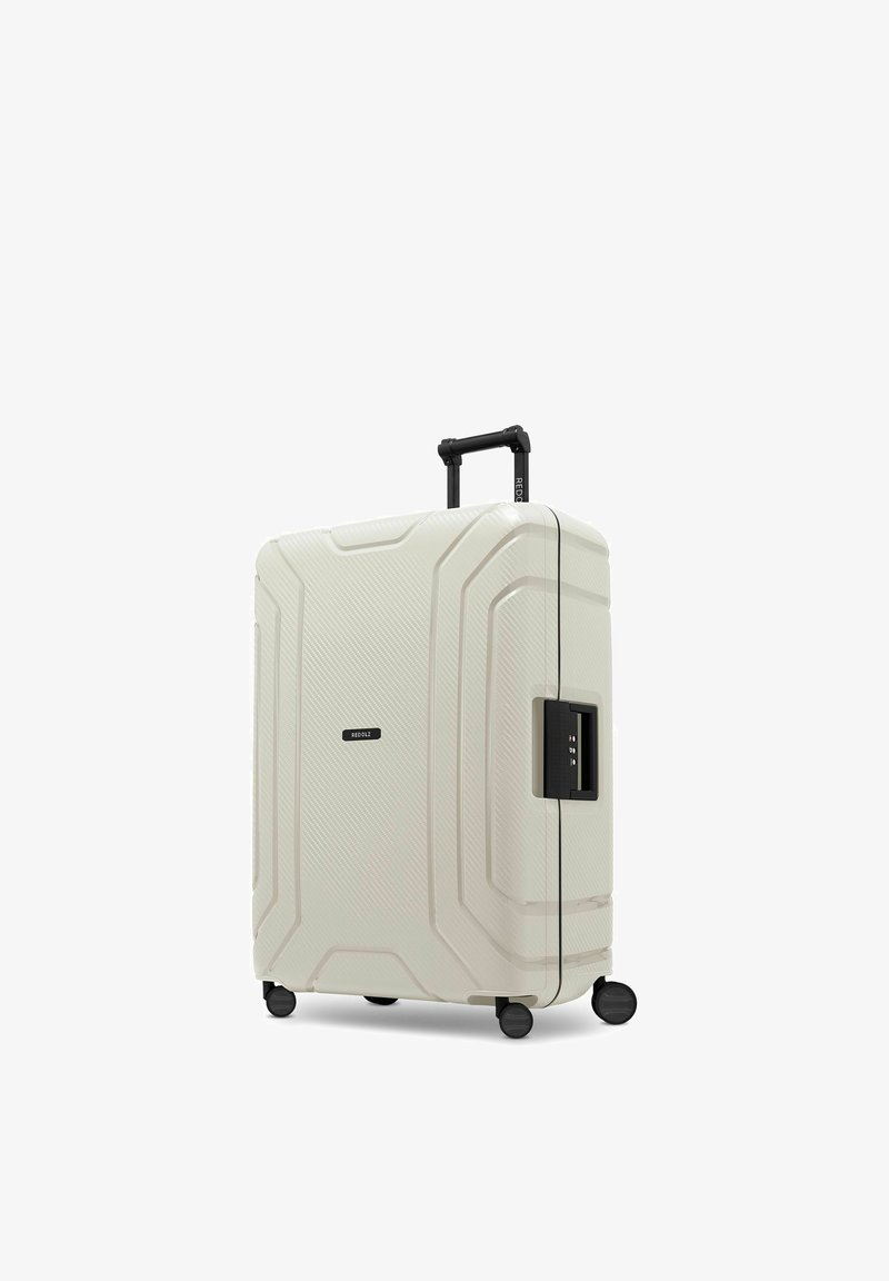 Valise rigide blanche avec quatre roues, poignée télescopique et serrure à combinaison latérale, debout sur fond blanc.