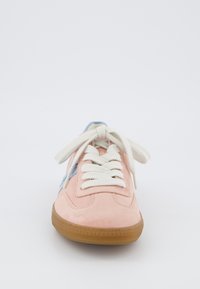 Világos rózsaszín velúr sneaker fehér fűzőkkel, kék részletekkel az oldalakon és barna gumitalppal, amely texturált felülettel rendelkezik.