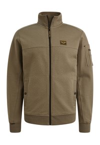 Olijfgroene zip-up jack met een gestructureerd voorpaneel, zijzakken, een hoge kraag en een patch op de linkerkant van de borst. Zachte stofafwerking.