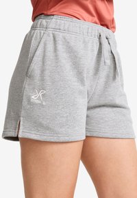 Grå shorts gjorda av en bomullsblandning, med resår i midjan, sidofickor och en liten logotyp broderad på framsidan.