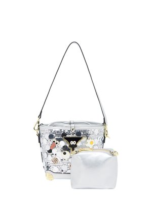 Silberne Handtasche mit schwarzem Riemen, verziert mit Pailletten und Cartoon-Augenflecken, neben einer kleineren schlichten silbernen Tasche mit goldenem Reißverschluss.