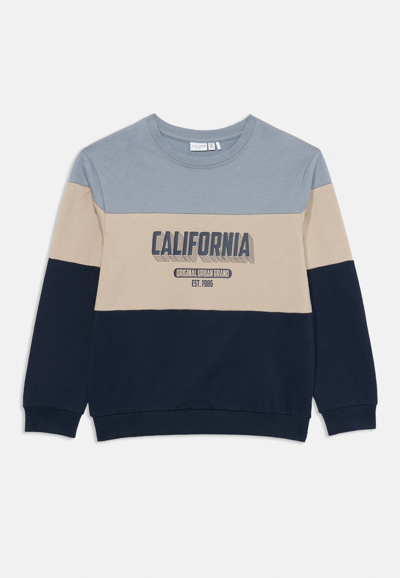 Dolga majica s kapuco v blokiranih barvah modre, bež in mornarske modre z napisom "CALIFORNIA Original Urban Brand Est. 1986" natisnjenim na prsih.