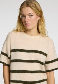 Lysebeige kortærmet sweater med mørkegrønne striber. Blødt, struktureret stof med rund halsudskæring og afslappet pasform.