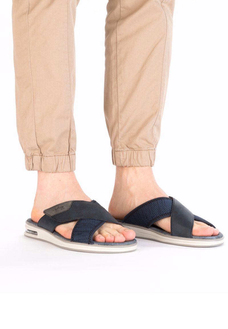 Sandales à brides croisées bleu marine avec une tige en tissu texturé et une semelle rembourrée. Design léger avec une semelle grise lisse et un léger talon.