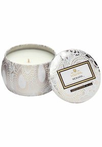 Kokosvaxljus i en rund metallbehållare. Har ett vitt blommönster på silverbakgrund. Gyllene etikett med "Mokara" och texten begränsad upplaga.