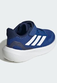 Navy athletic shoe with a textured mesh upper, white accents, Velcro strap, and a thick white rubber sole for support and durability.