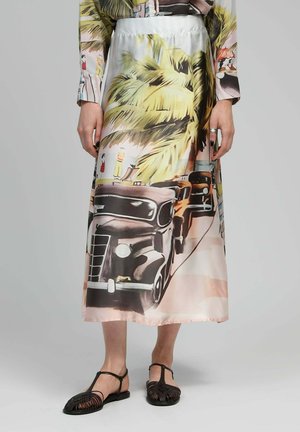 Jupe longue en satin avec un imprimé coloré de palmiers et de voitures vintage. Le tissu a une texture lisse avec un drapé léger.