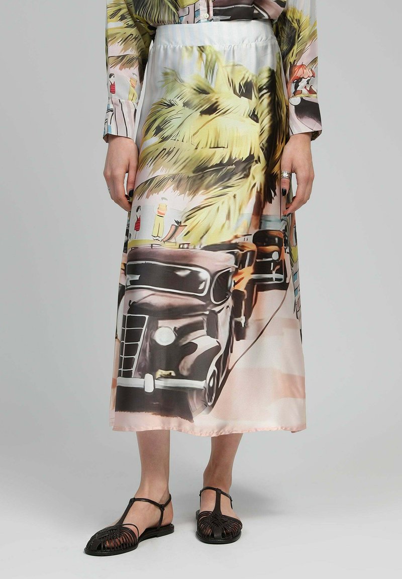 Jupe longue en satin avec un imprimé coloré de palmiers et de voitures vintage. Le tissu a une texture lisse avec un drapé léger.