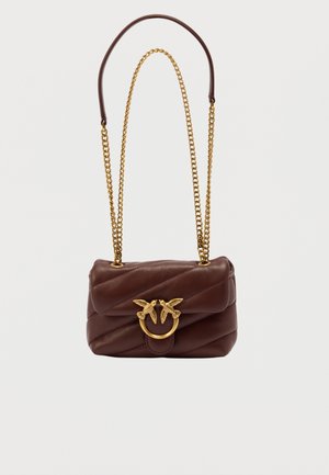 Brązowa pikowana torba na ramię ze skóry z złotym łańcuszkowym paskiem i ozdobną złotą klamrą przedstawiającą dwa ptaki zwrócone do siebie.