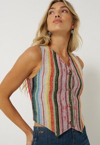 Meer kleurige gestreepte spencer met een V-hals, met tinten rood, groen, blauw en geel, en decoratieve knopen aan de voorkant.