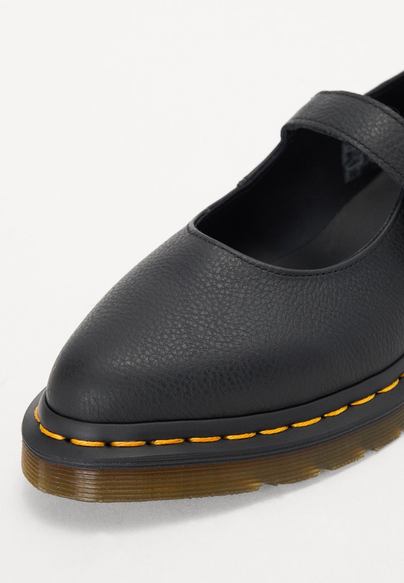 Black leather Mary Jane shoe with a textured upper, pointed toe, and an orange stitched edge. Features a single strap across the instep.