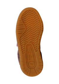 Semelle de chaussure en caoutchouc avec un motif de bande de roulement en zigzag, de couleur fauve. Un logo est visible près du centre, avec des accents noirs sur les côtés.