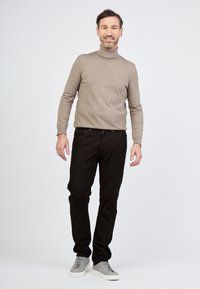 Beige kaulusneule, mustat housut, harmaat lenkkarit. Pehmeä tekstuuri, slim fit -leikkaus ja rento muotoilu. Vähän hardwarea ja yksityiskohtia näkyvissä.