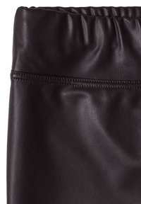 Gros plan d’un vêtement en cuir marron foncé avec une couture piquée et un détail de ceinture élastique froncée.