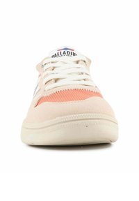 Ljusrosa mockasneaker med vita snören, texturerade orange paneler och en gummisula. Logotypen på tungan har röda och blå accenter.