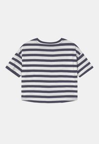 Krátký rukáv, námořnická modrá a bílá horizontálně pruhovaná zkrácená tričko s kulatým výstřihem položené na bílém pozadí.