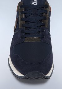 Sneaker blu navy con camoscio testurizzato e nylon, con accenti grigio scuro. Dettaglio in ecopelle sul tallone e suola intermedia bianca a contrasto.